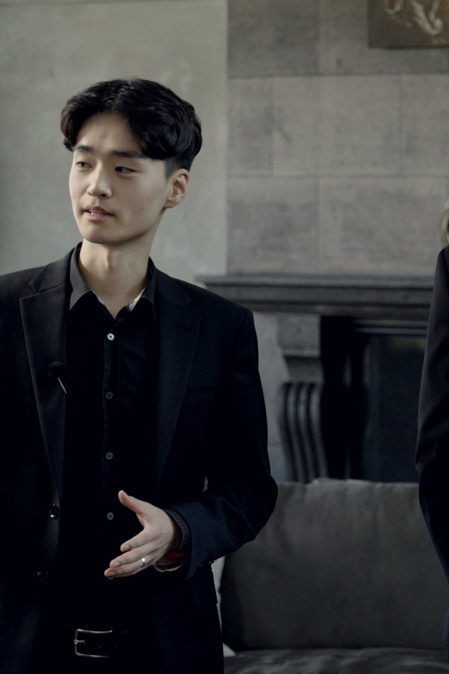 On set: a man in a black suit explains the rules